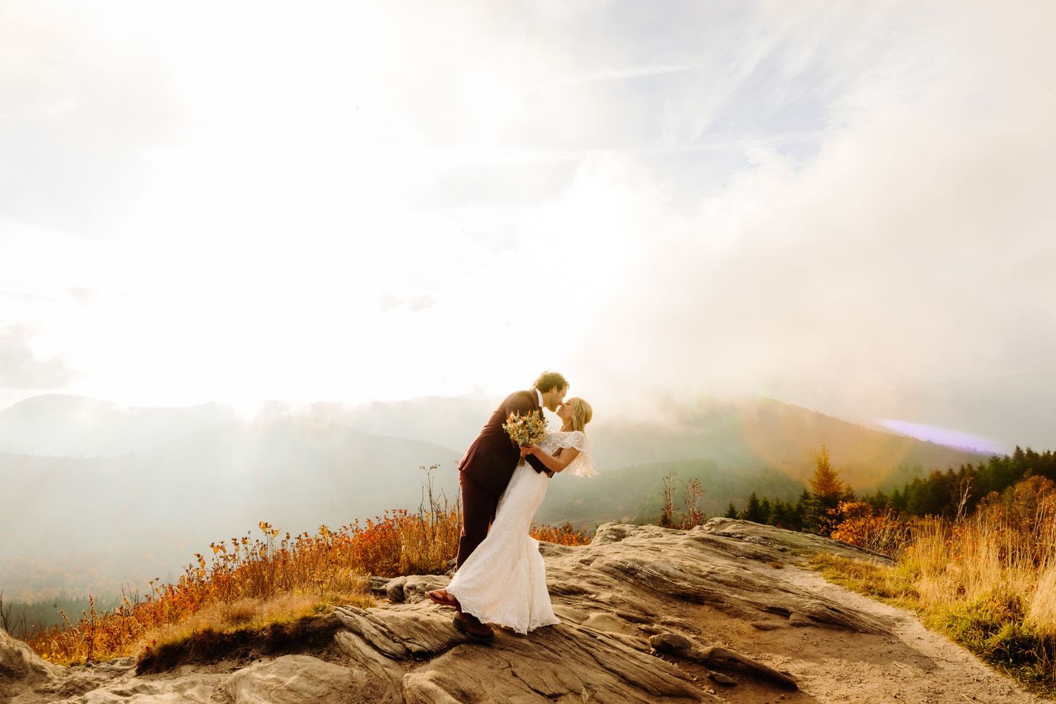 Romantic sunset embrace on dramatic mountain clifftop.