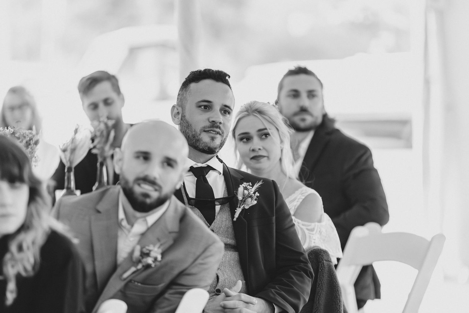 Wedding party members in formal attire gathered for candid photos.
