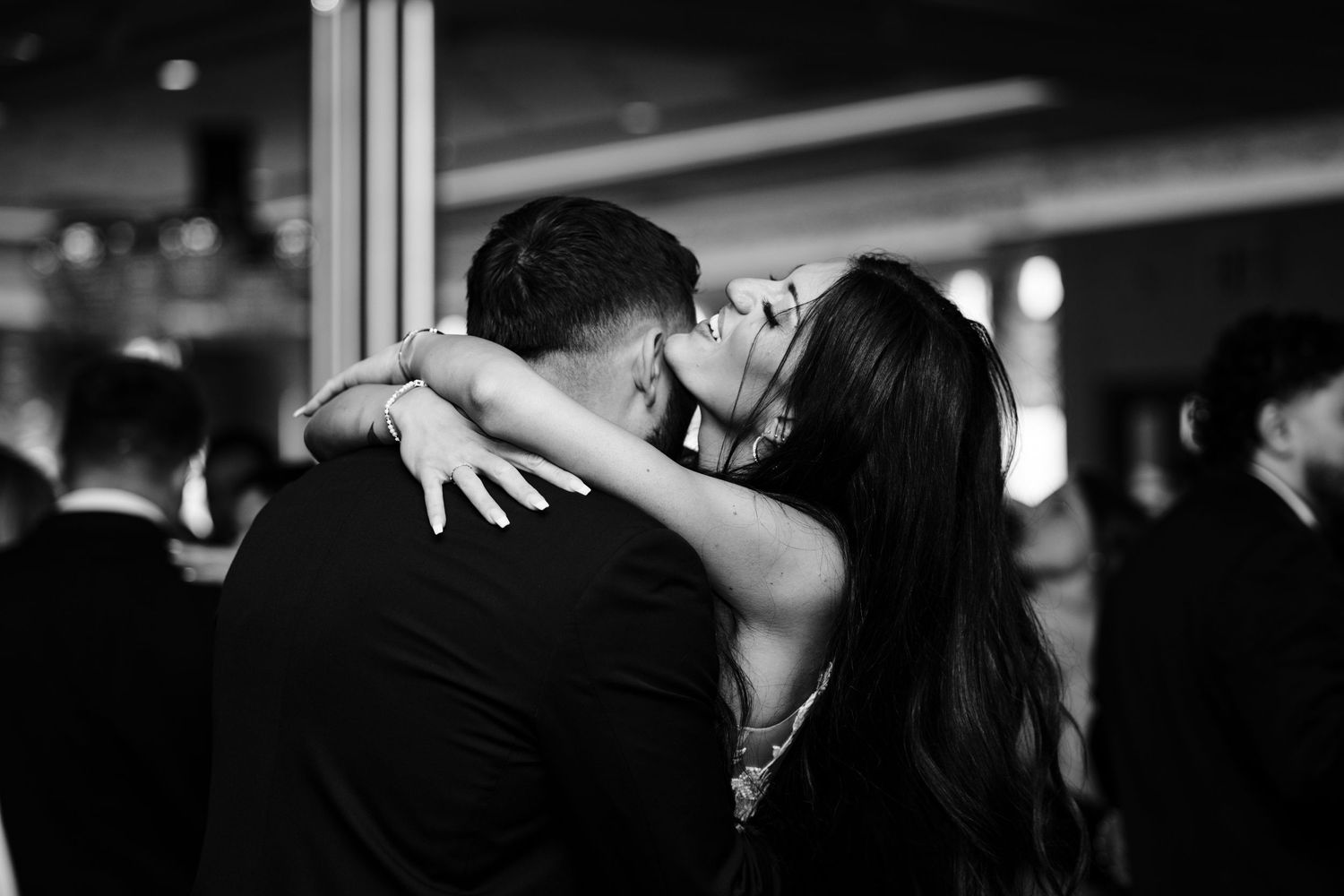Black and white photo captures an intimate slow dance between newlyweds at their wedding reception.