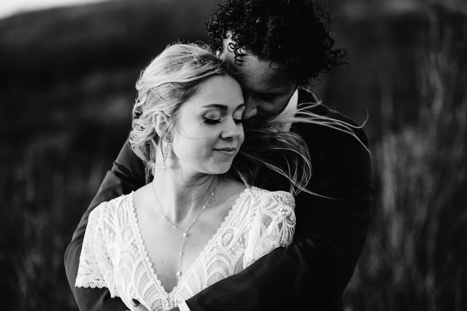 An intimate black and white portrait showing a tender moment between newlyweds.