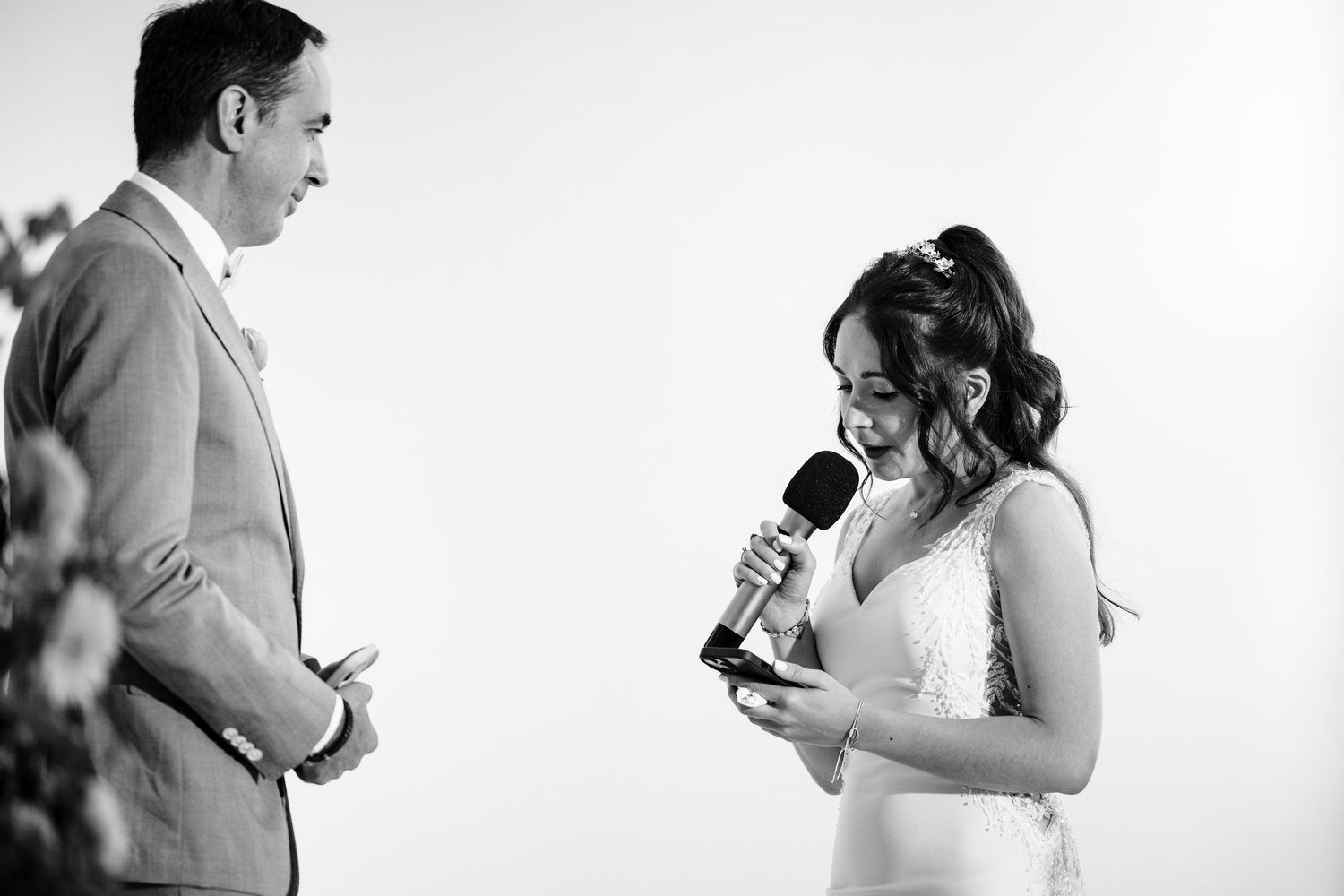 A couple exchanges emotional vows during their wedding ceremony with microphones.