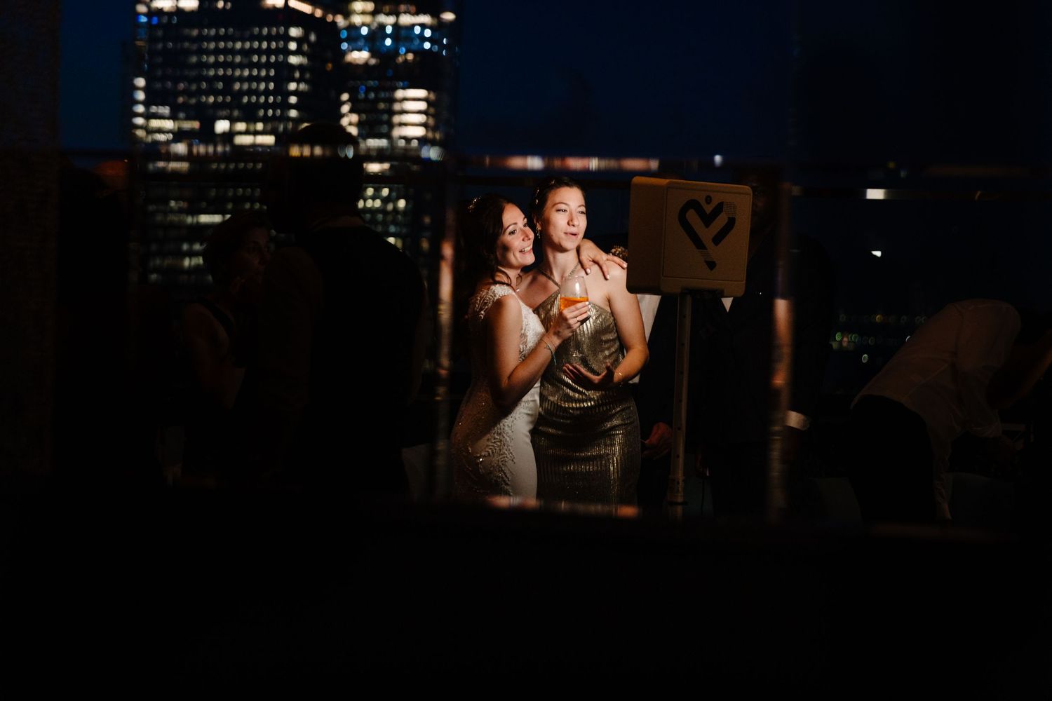 Dancing crowd silhouettes against a dark nightclub background with city lights.