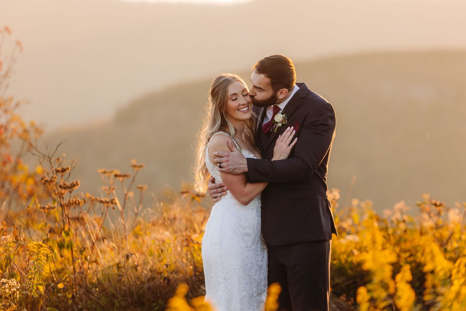 Candid moment between newlyweds during golden hour with mountain backdrop.
