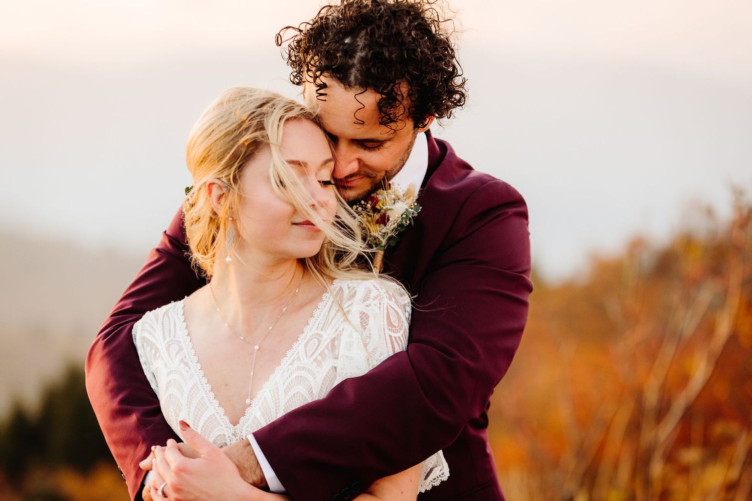A warm embrace captured in autumn colors against a mountain backdrop.