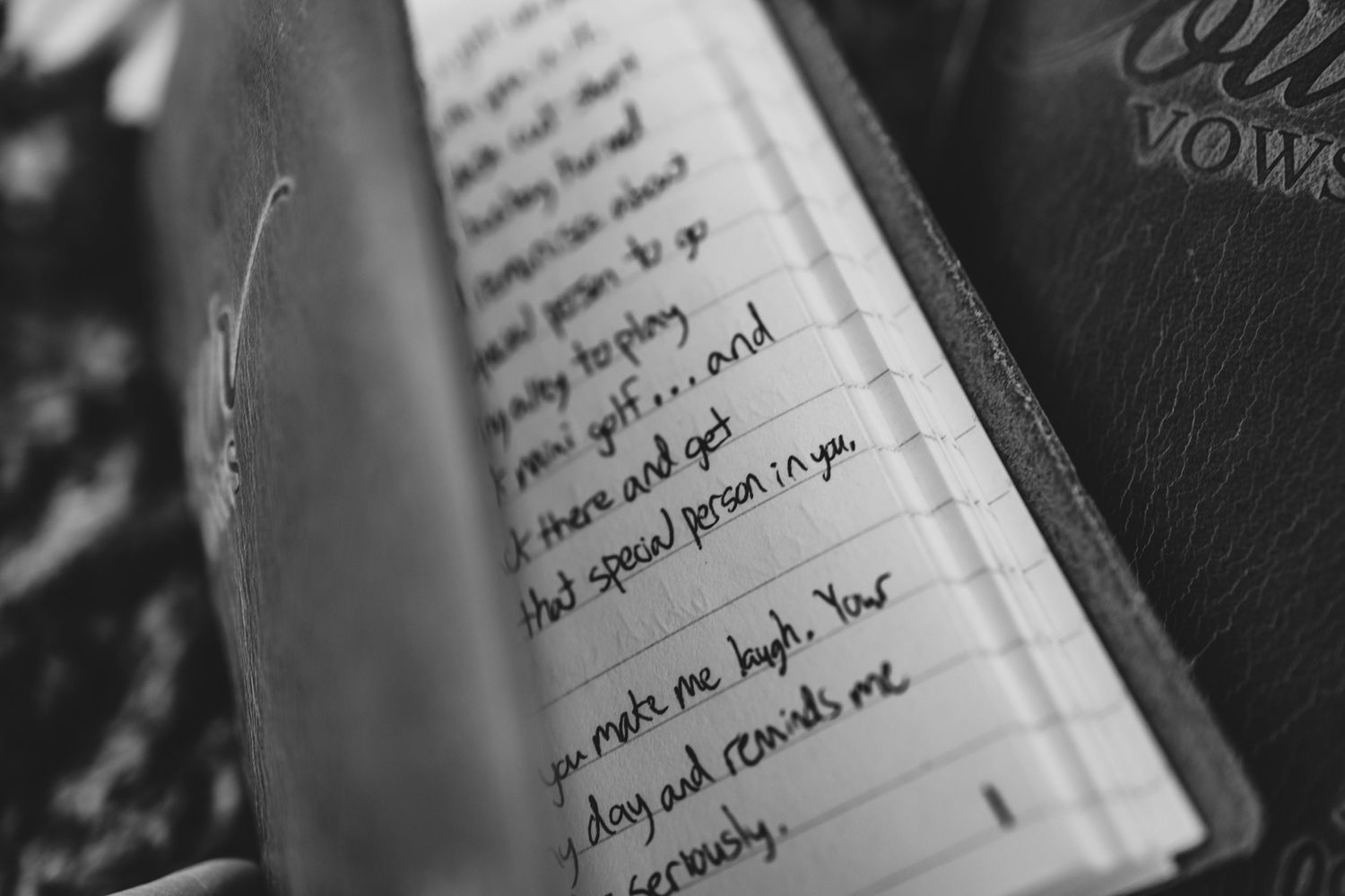Close-up black and white image of handwritten vows in an open book.