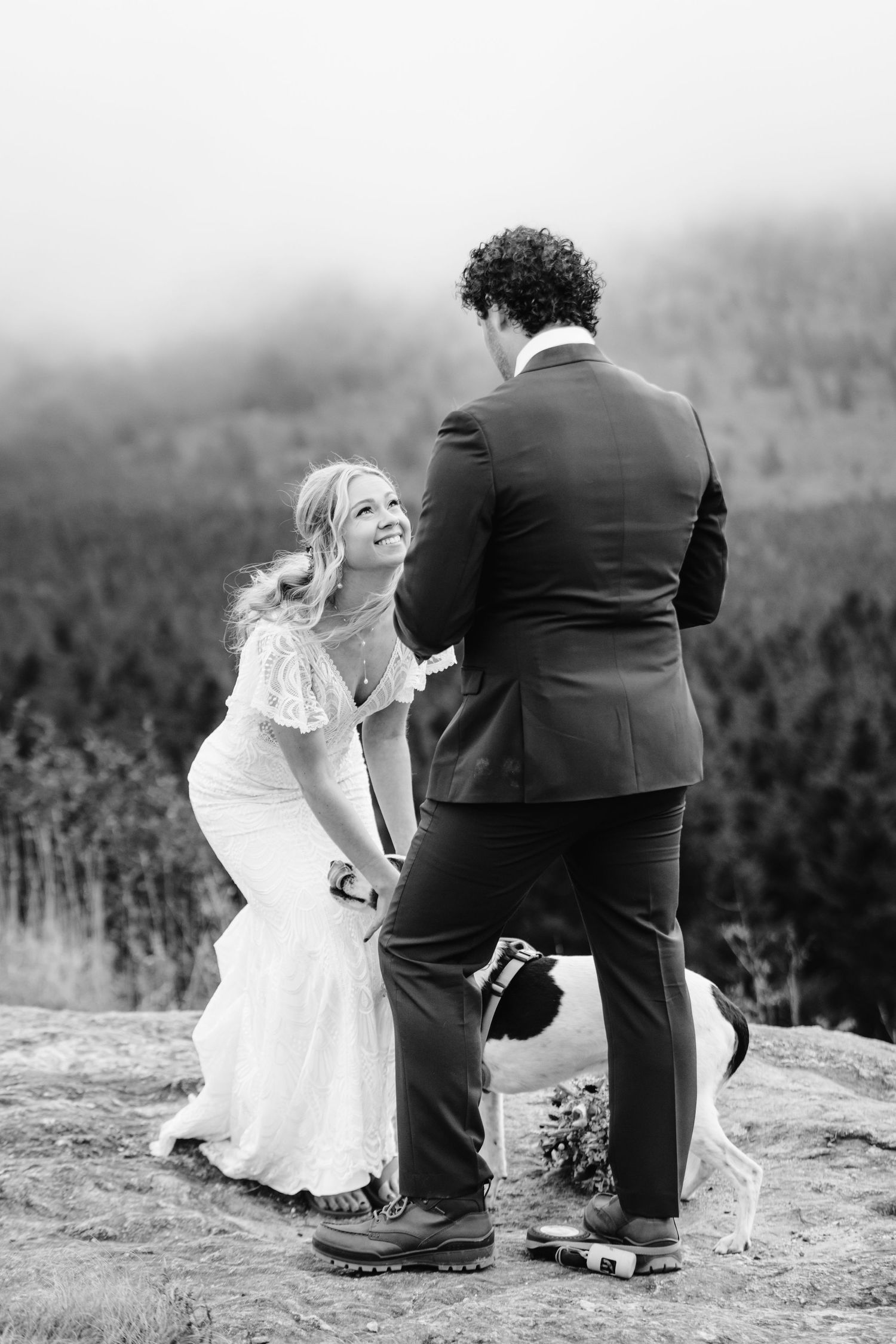 A couple exchanging vows during an intimate mountaintop ceremony in black and white.