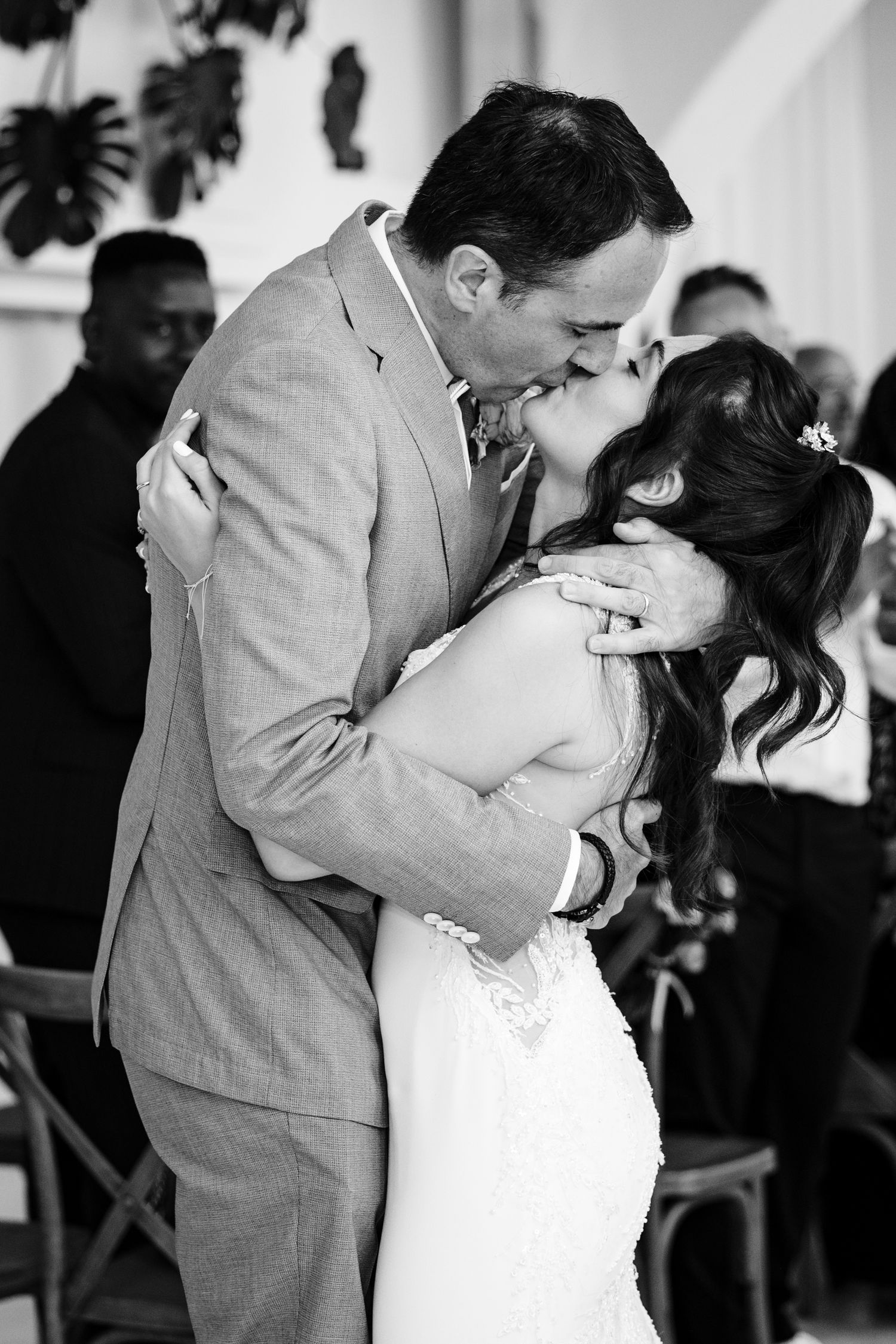 A romantic kiss between newlyweds at their wedding reception.