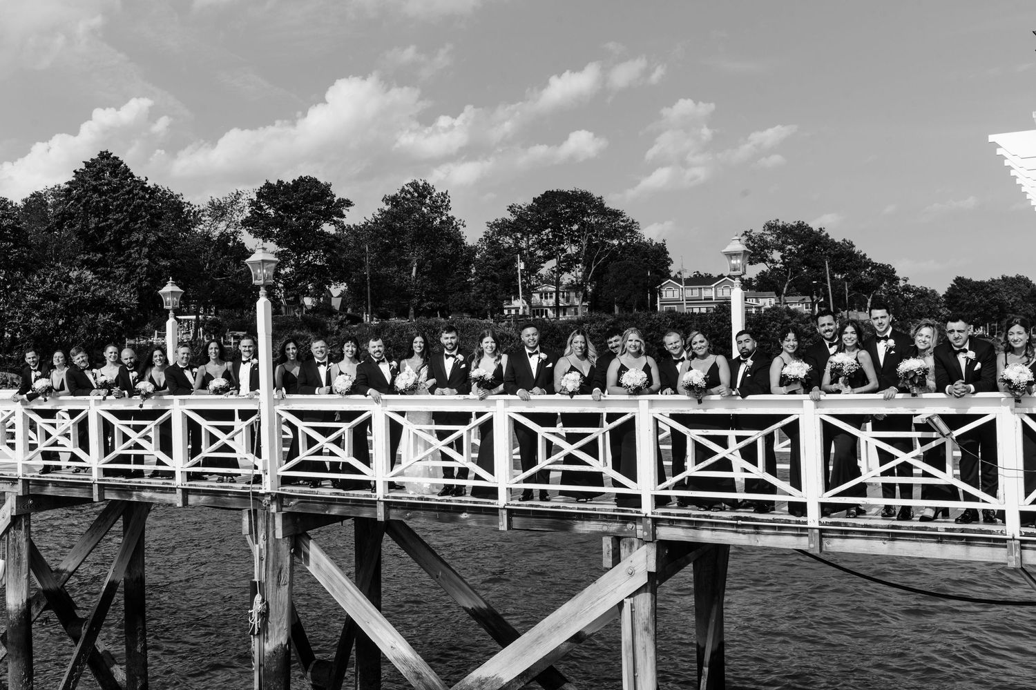 White outdoor wedding venue with decorative pergola and railings on a sunny day.