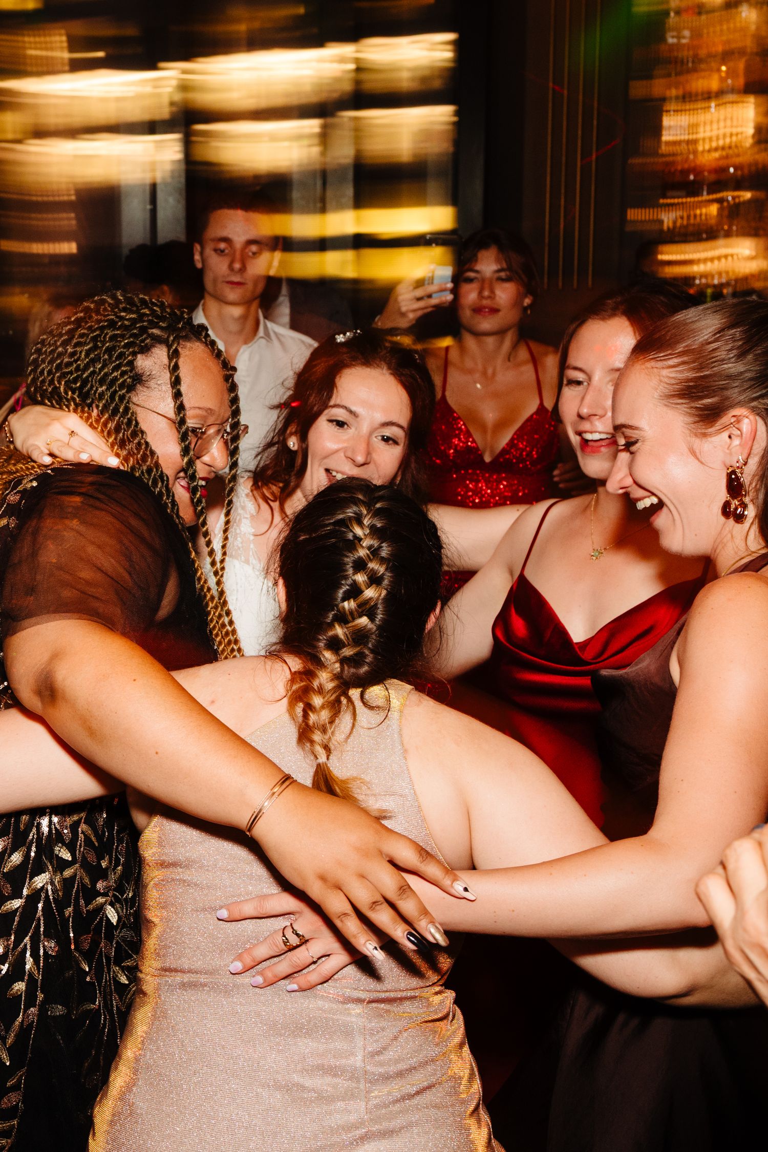 Group of wedding guests laughing and dancing together at a festive reception.