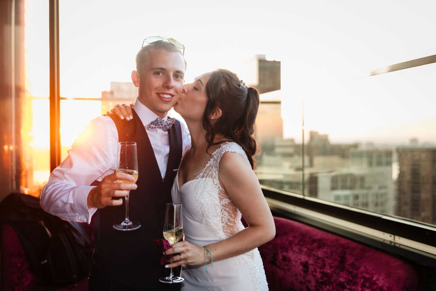 Sunset wedding celebration on rooftop venue with champagne toast.