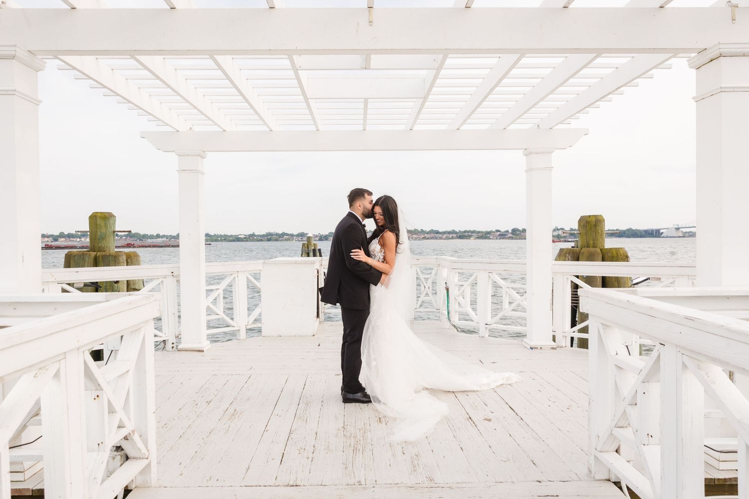 Wedding photography session on a bright white pier with romantic architectural details.