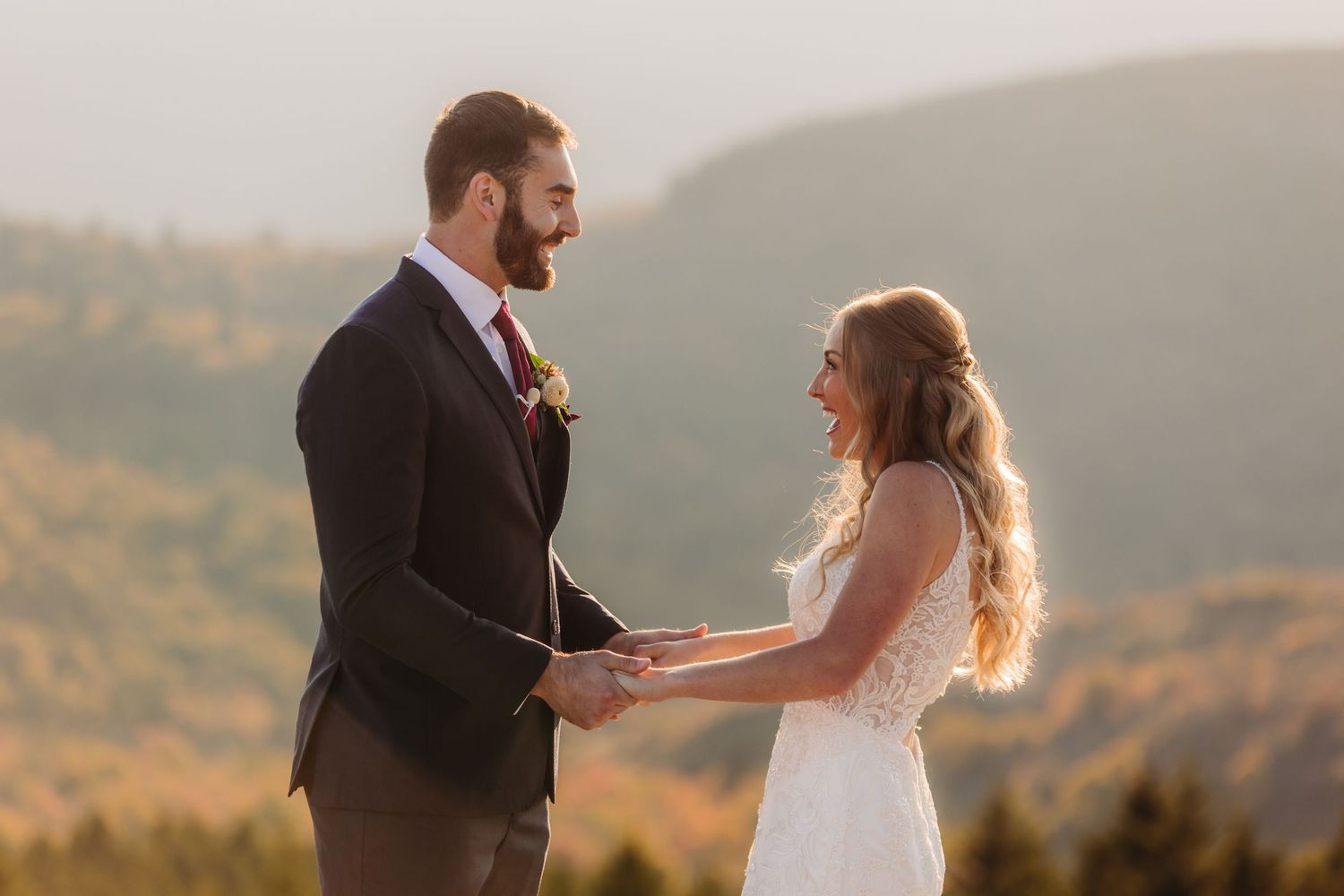 Intimate wedding moment captured during sunset with mountains and autumn colors in the background.