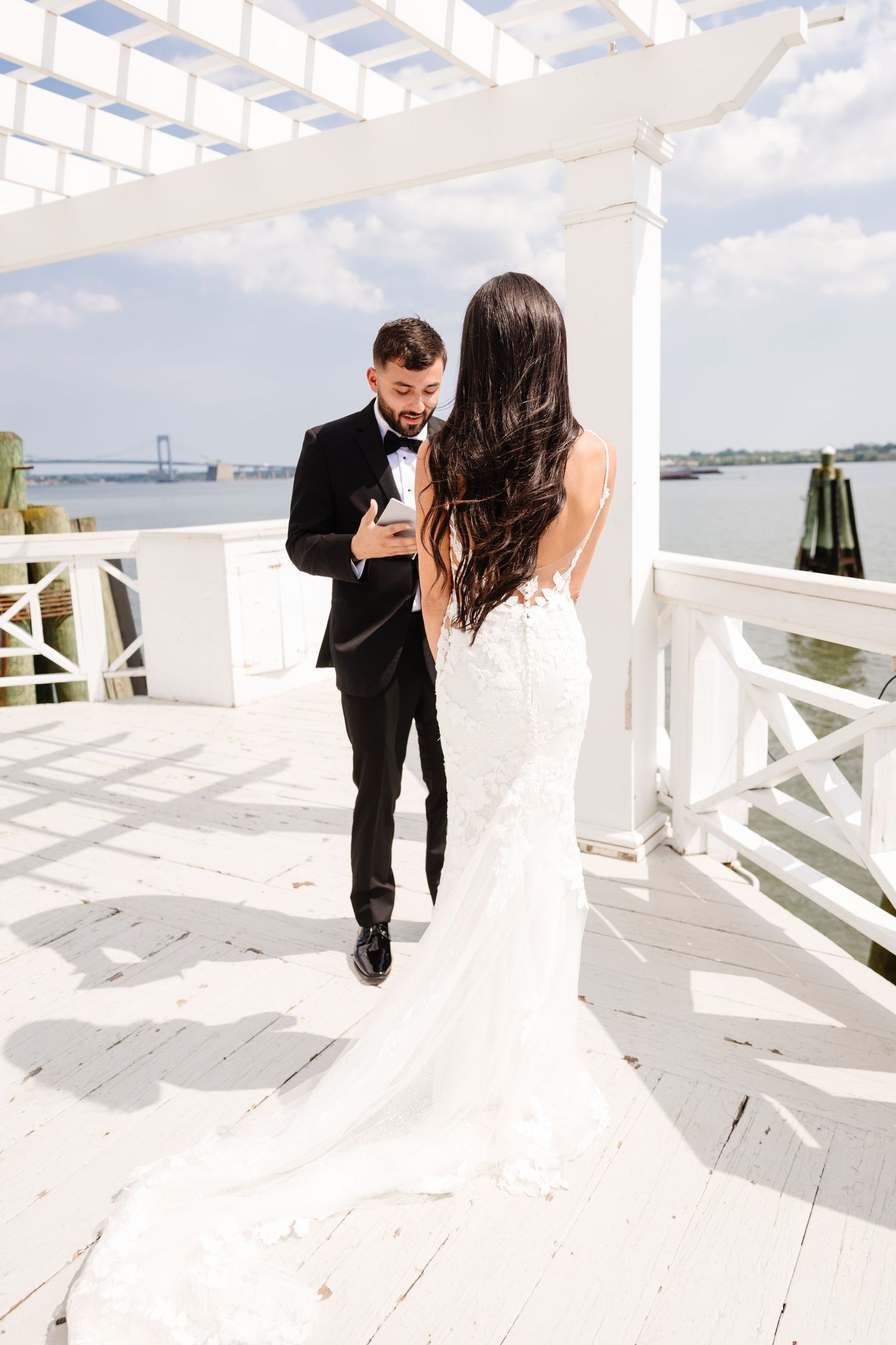 Romantic wedding portraits on a white deck overlooking the harbor.