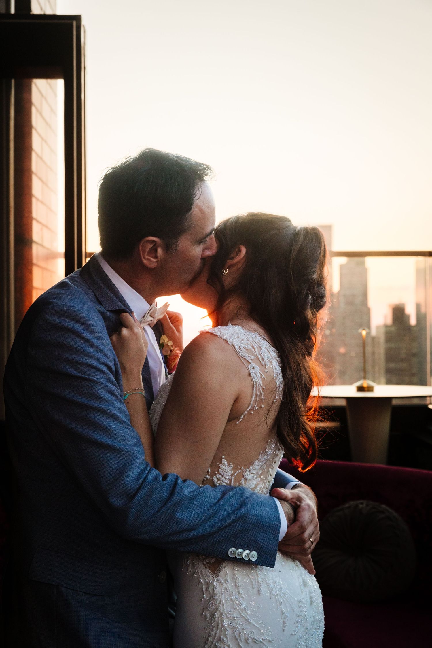 Romantic sunset embrace on NYC rooftop with cityscape backdrop.
