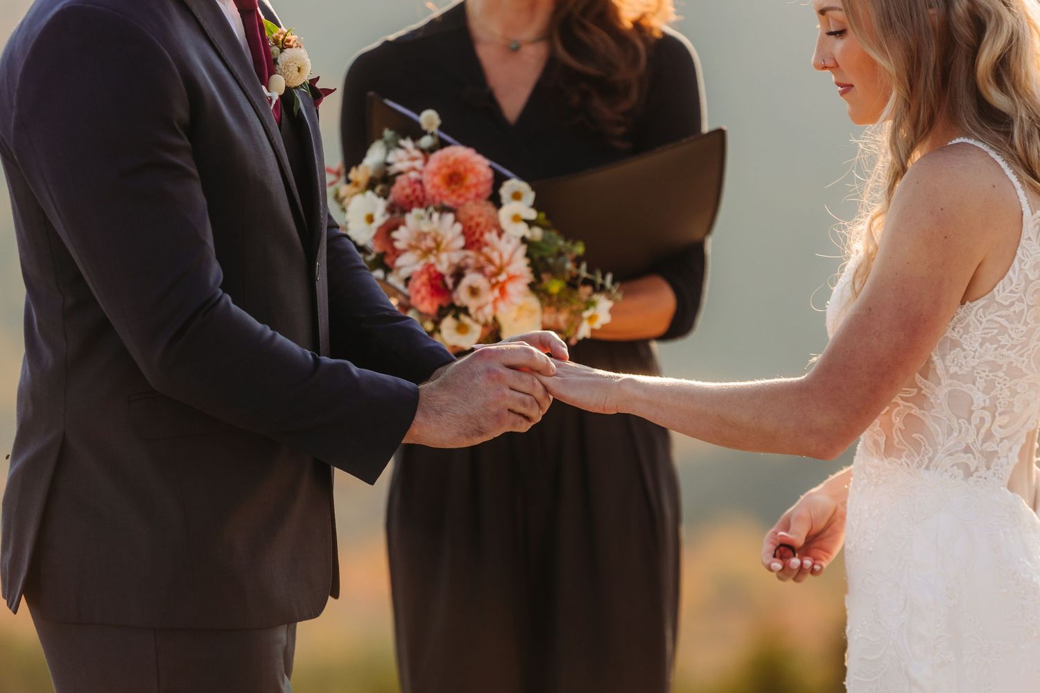 Wedding ceremony details with floral arrangements against mountain backdrop.