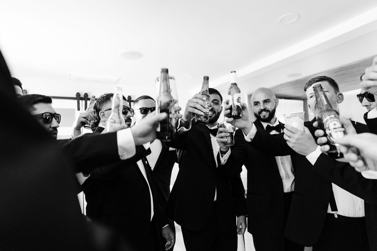 Wedding party members in black attire pose together in silhouette.