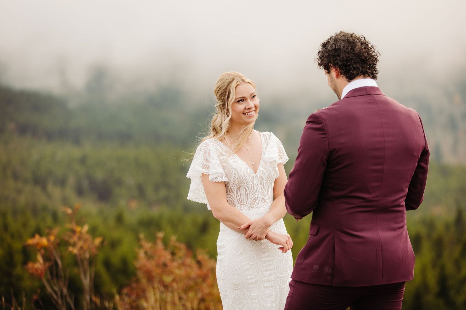An intimate wedding ceremony takes place against a backdrop of autumn mountain scenery.