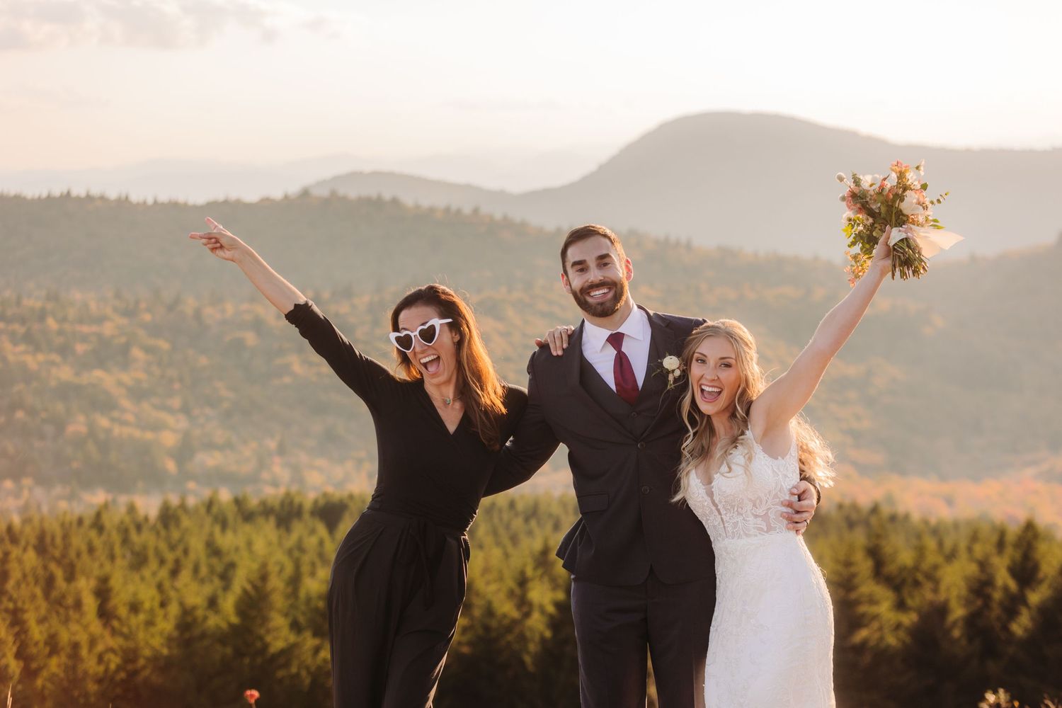 Joyful celebration moment at mountain wedding with autumn scenery in the background.