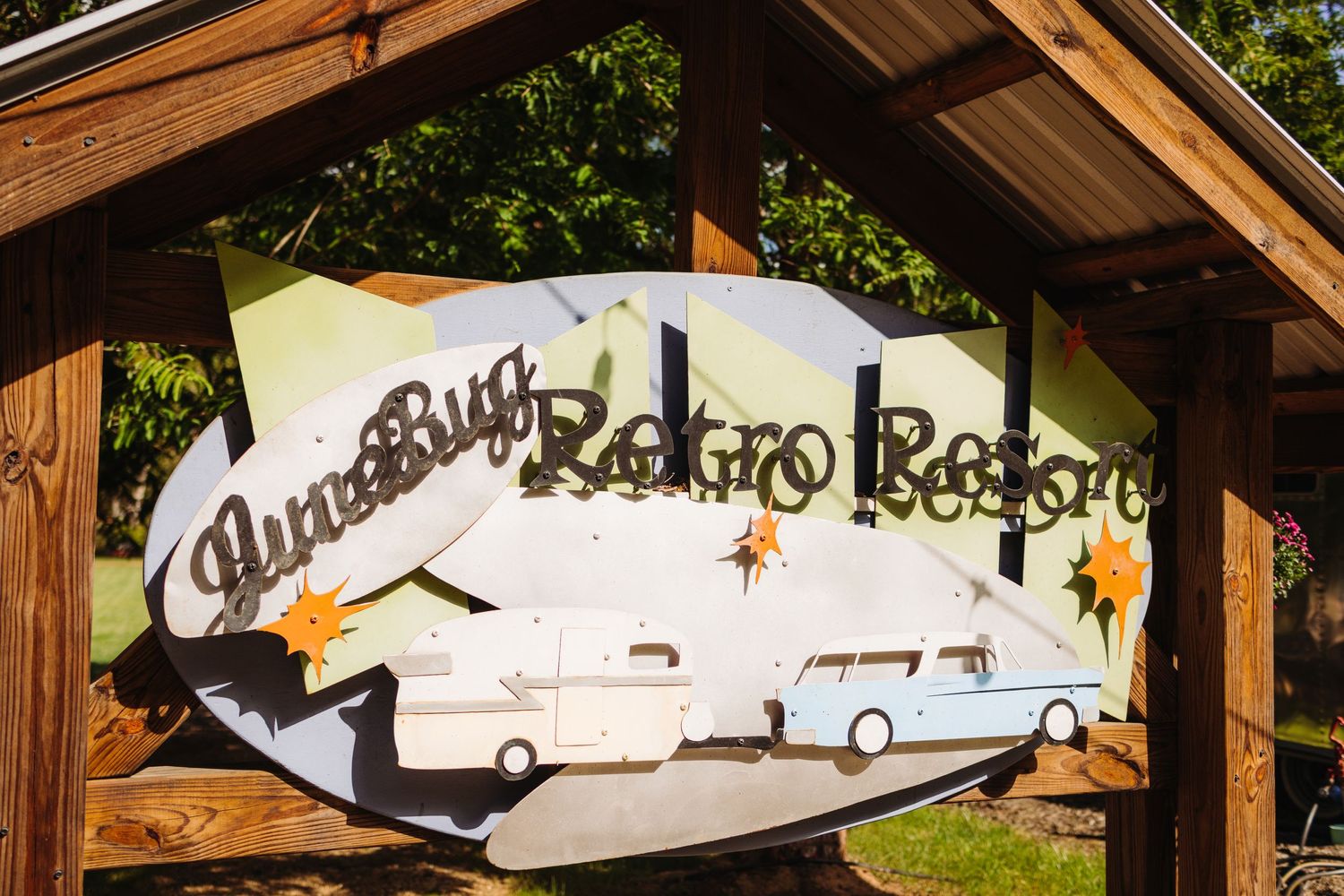 Rustic wooden pavilion with decorative signage and natural greenery overhead.