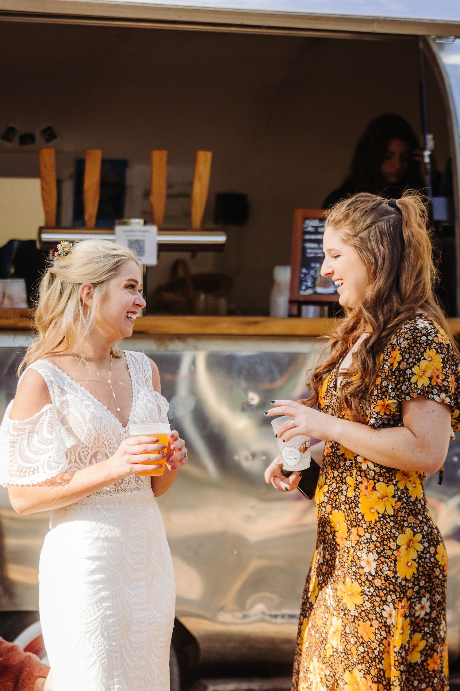 Wedding celebration with people in white and floral dresses dancing and laughing together.