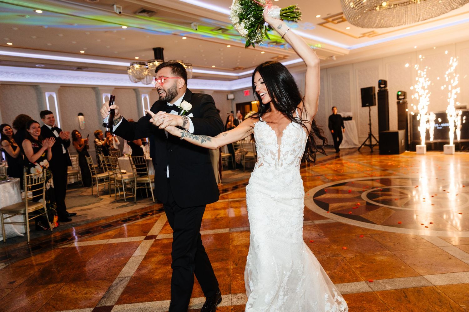 Wedding reception dance floor with elegant lighting and ornate ceiling details.