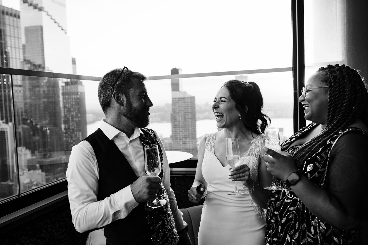 Candid black and white wedding reception photo on NYC rooftop terrace.