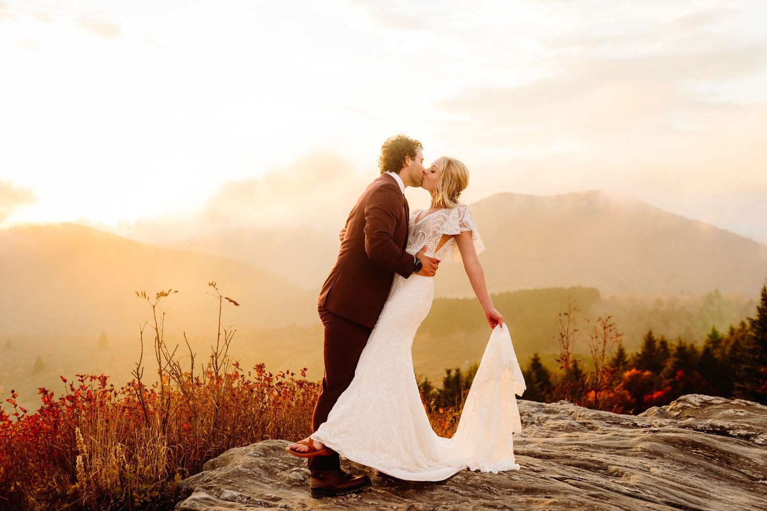 A romantic dance pose on a mountain overlook during golden hour.