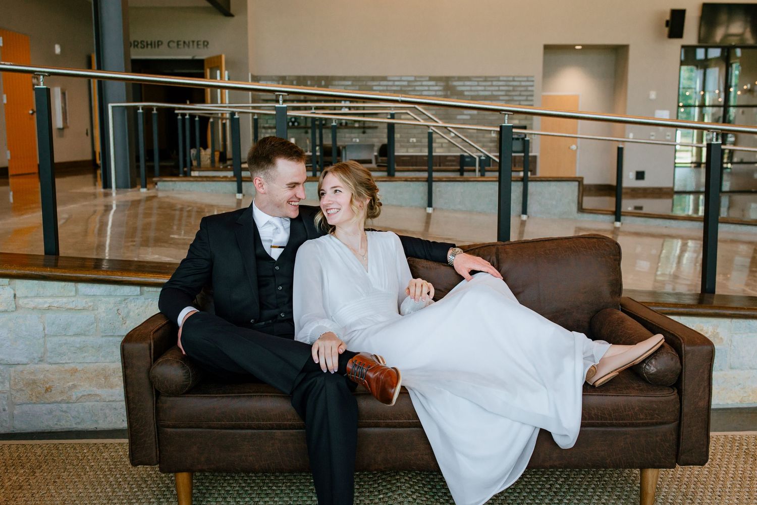 Bride and groom and their micro wedding at Grace Bible Church in College Station, Texas. They sit next to each other smiling together.
