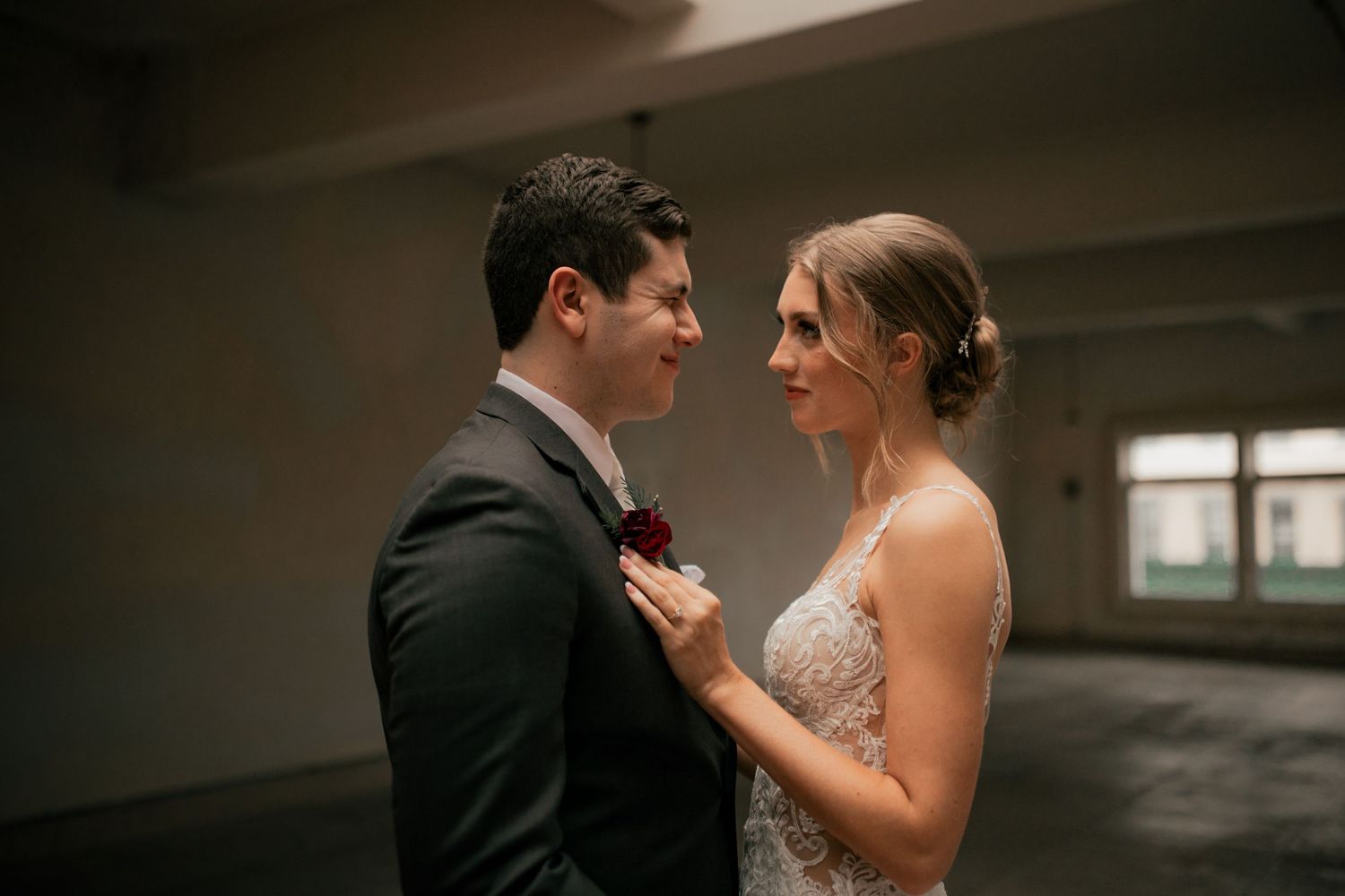 Married couple looking at each other at a wedding venue in Navasota, Texas. She is resting her hand on his chest and they are smiling softly