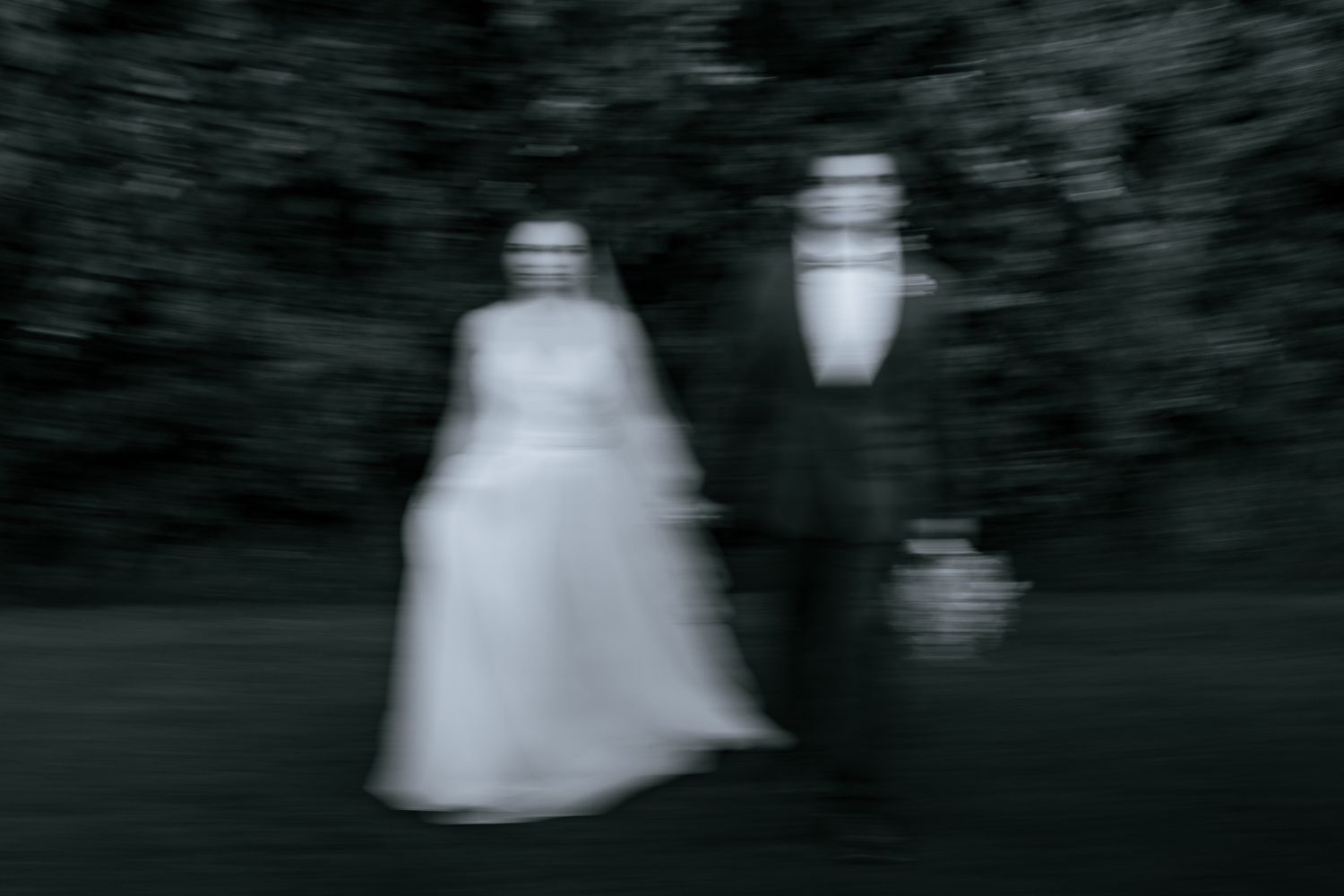 Bride and groom stand next to each other in black and white. Dramatic, stylized, editorial portrait.