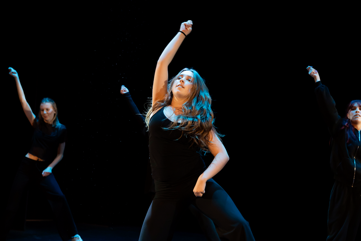 Dansföreställning med Dansstudion på Arenan i Karlstad. Koreografi av Evelina. Ensam dansare som sträcker armen uppåt.