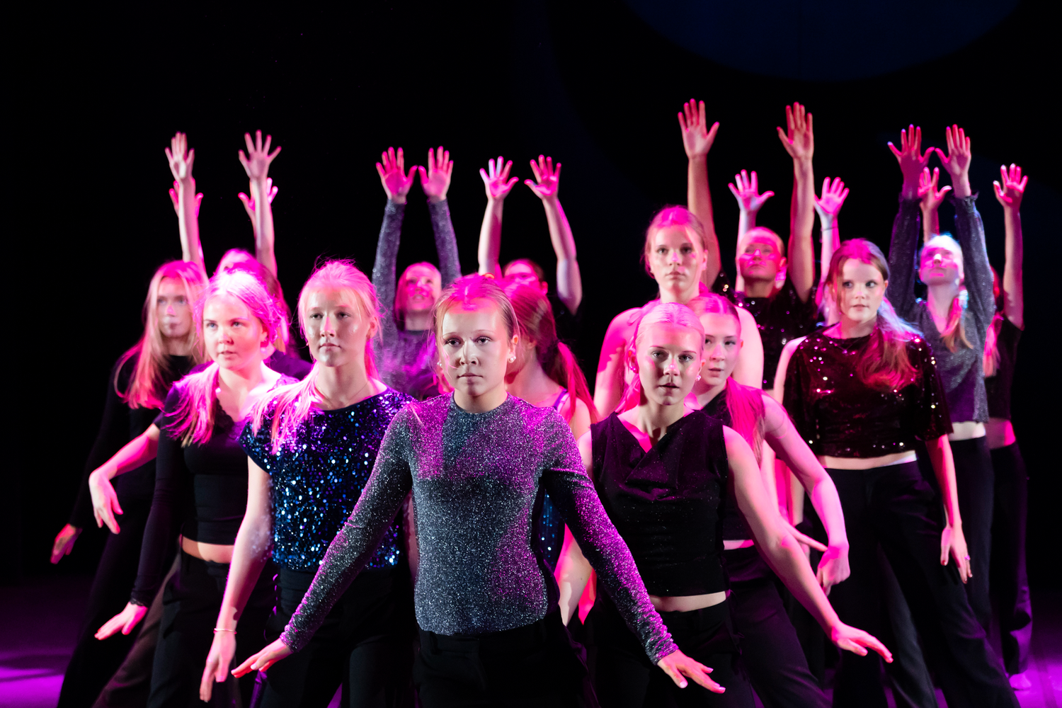 Dansföreställning med Dansstudion på Arenan i Karlstad. Koreografi av Evelina. Dansgrupp i lila ljus.