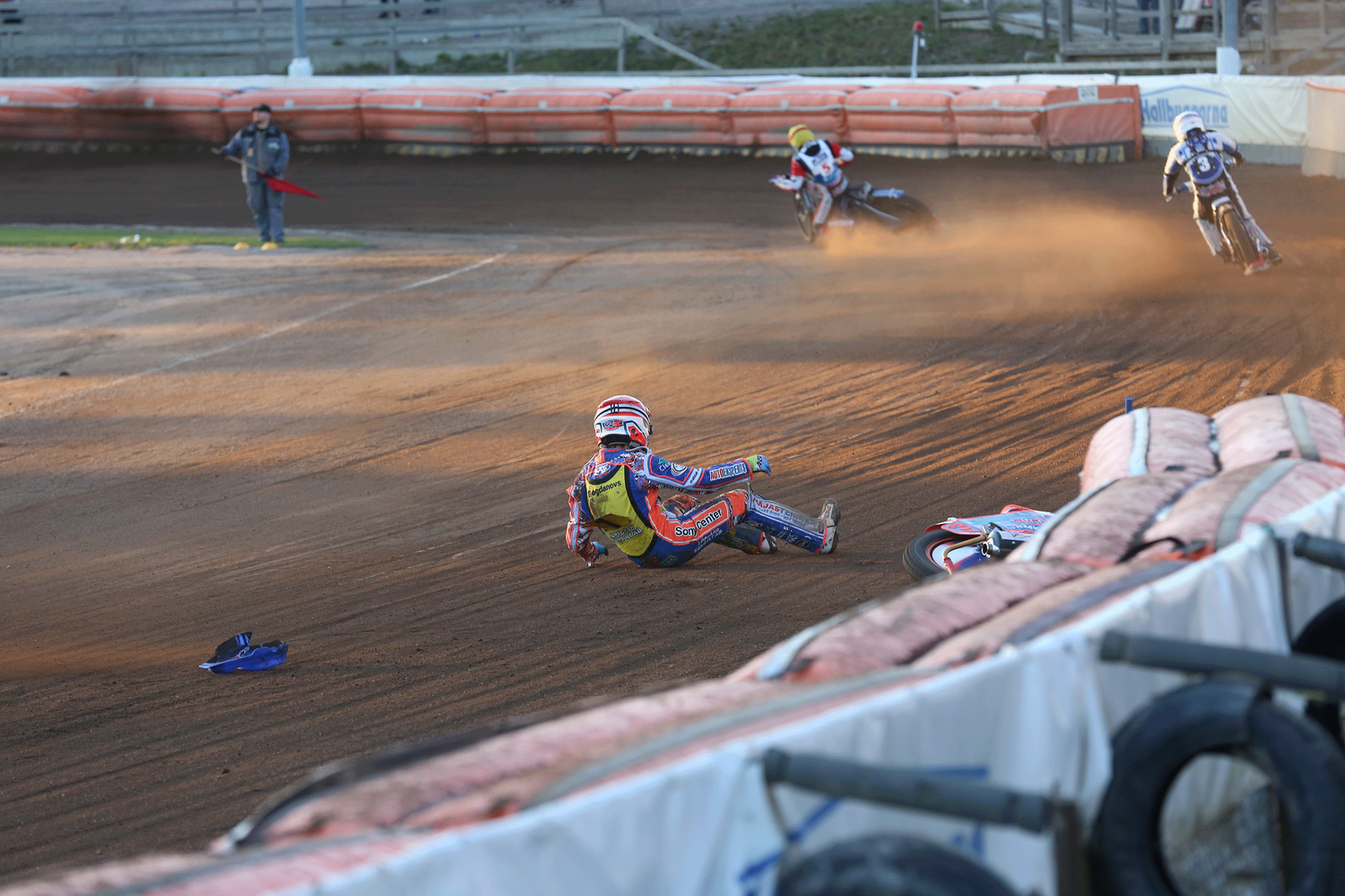 Speedwaybild från Avesta. En förare har ramlat och ligger på backen.
