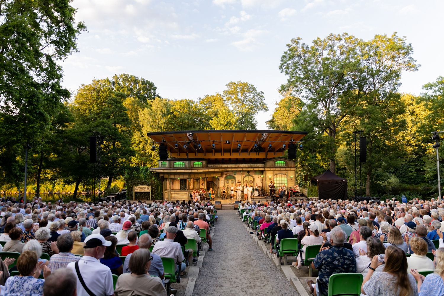 Musikalkväll med Peter Johansson och Emmi Christensson. Överblicksbild över scenen på Vallarnas Friluftsteater bakifrån med publiken.