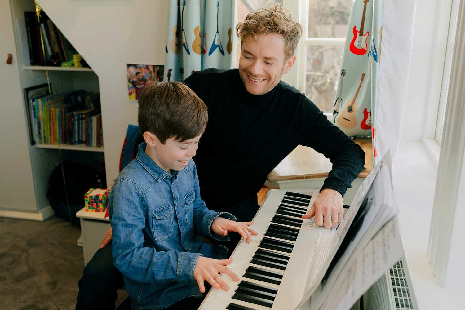 Familjefotografering på familjen Johansson. Peter och Hayden spelar piano tillsammans.