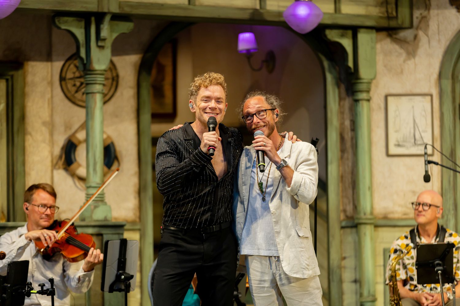 Musikalkväll med Peter Johansson o Emmi Christensson. Peter Johansson och Lars Säfsund håller om varandra och sjunger.