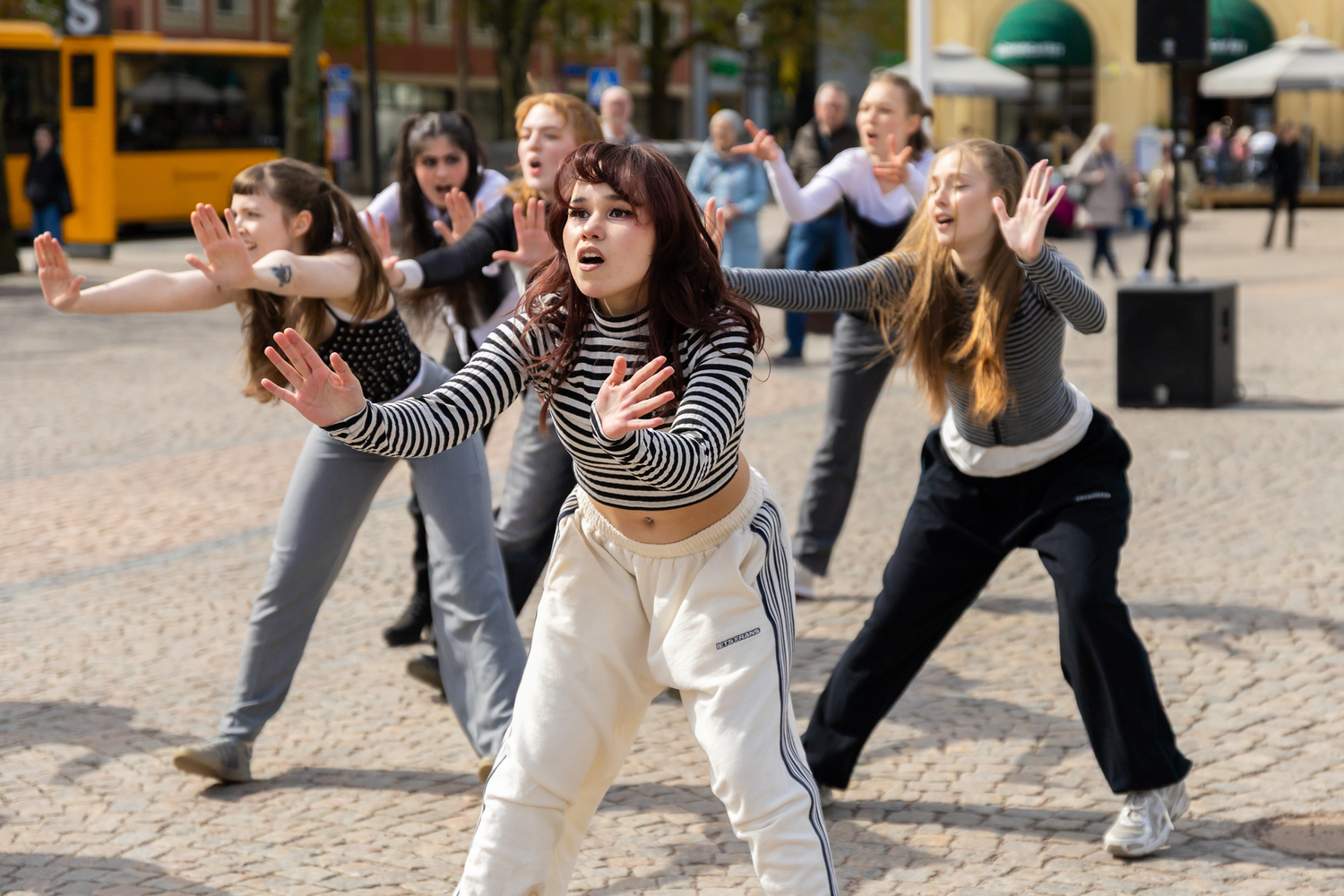 Dansens dag på stora torget i Karlstad. Dansar i grupp med en tjej är mer i skärpa. Hon har randig tröja. Dansare från Karlstads Universitet