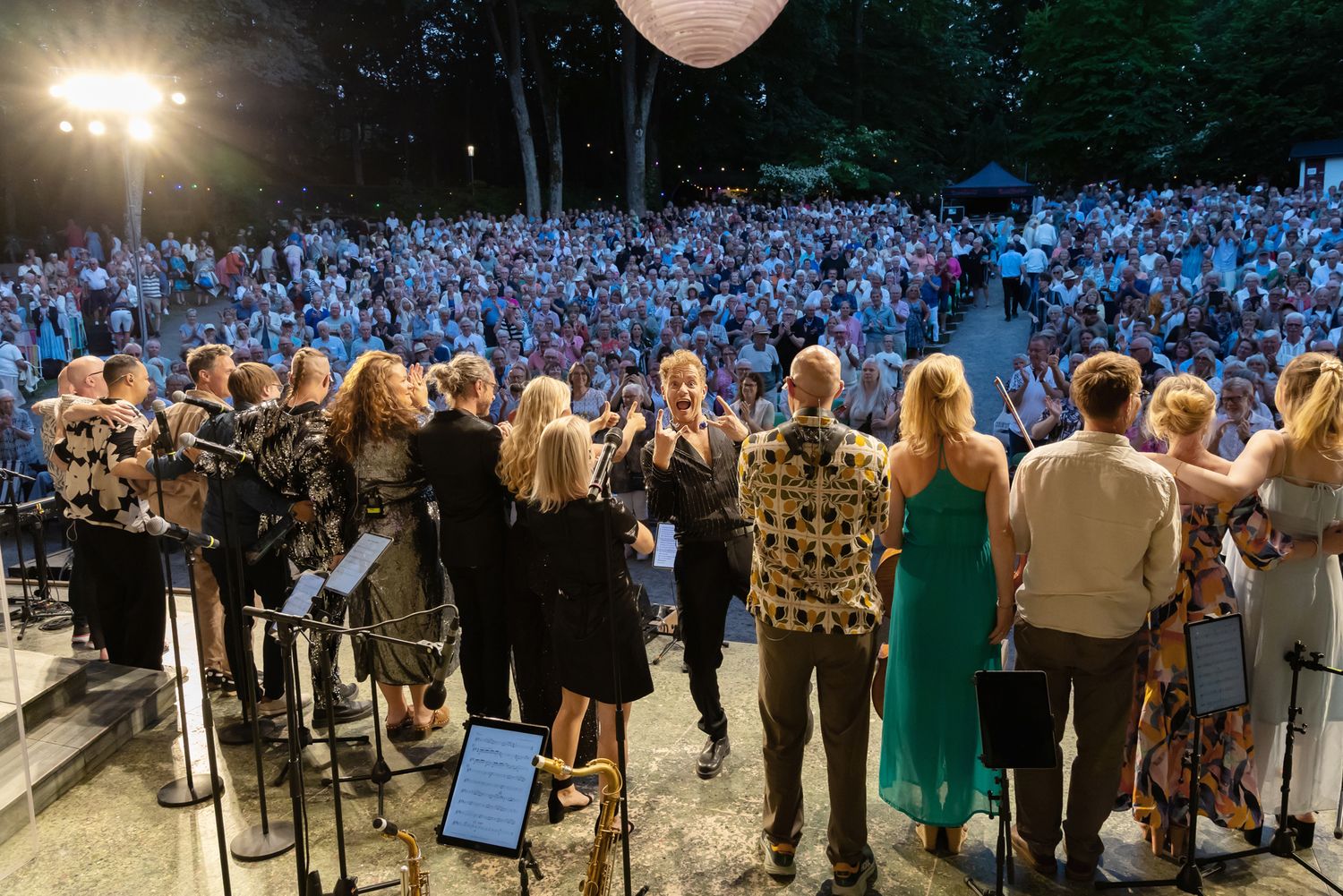 Musikalkväll med Peter Johansson o Emmi Christensson. 2entertain. Applådtack med hela gänget.  Peter vänder sig om och tittar in i kameran.