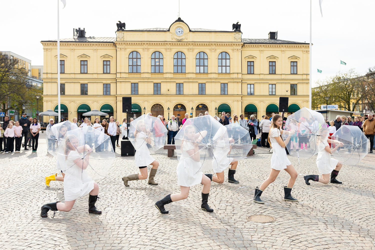 Dansens dag på stora torget i Karlstad.  Forshaga kulturskola dansar i vita klänningar med paraplyer.