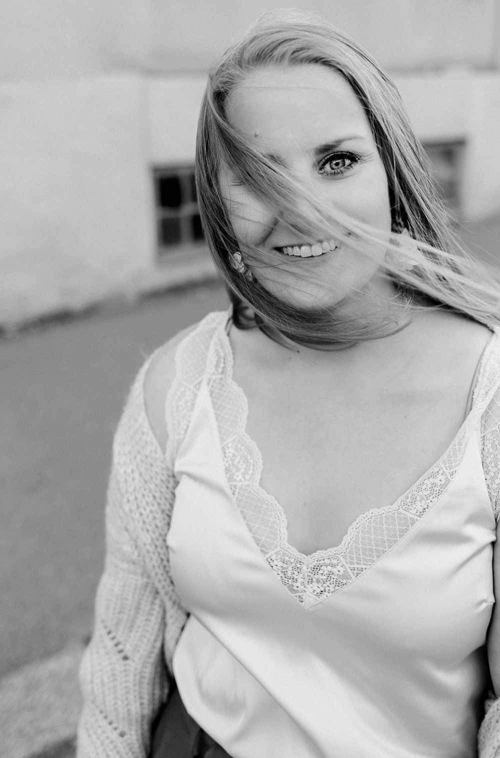 Porträtt mig på, fotograf Rebecca Nordin. svartvit och håret som flyger framför ansiktet så enbart ett öga syns.