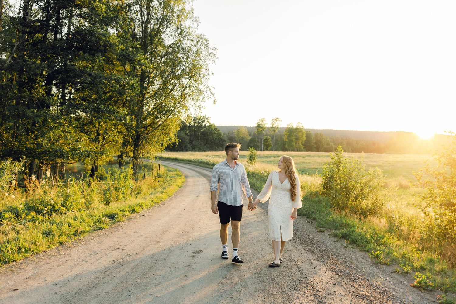 Parfotografering med Martina och Sebastian i Borgvik utanför Karlstad. Gående på grusväg i solnedgång.