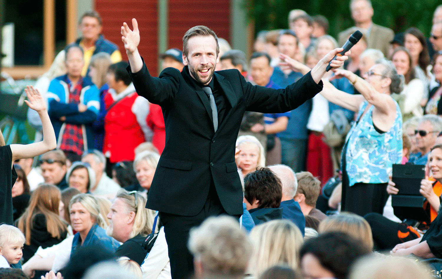Johan Östling håller i Allsång på Sandgrundsudden. Han står mitt i publiken.