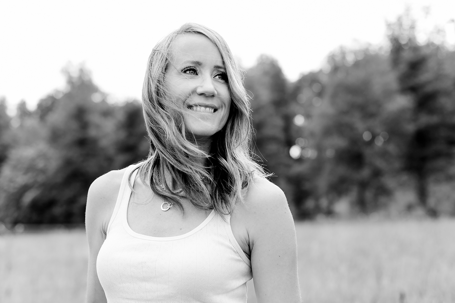 Svartvitt porträtt på Matilda Grün. Håret fladdrar i vinden och hon har ett vitt linne på sig.