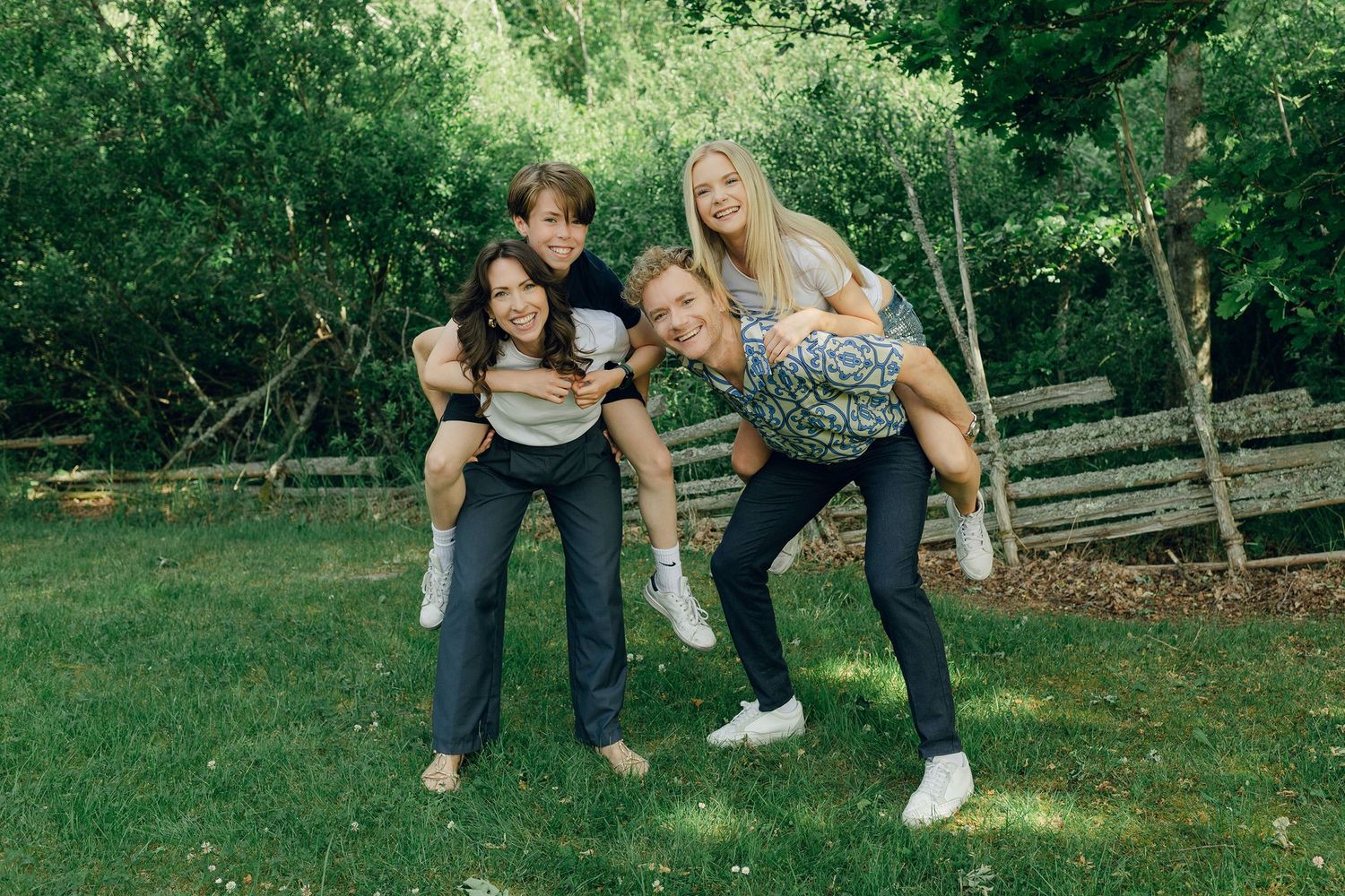 Familjefotografering med Peter, Lydia, Millie och Hayden Johansson. Fotograf Rebecca Nordin. Barnen på föräldrarnas rygg.