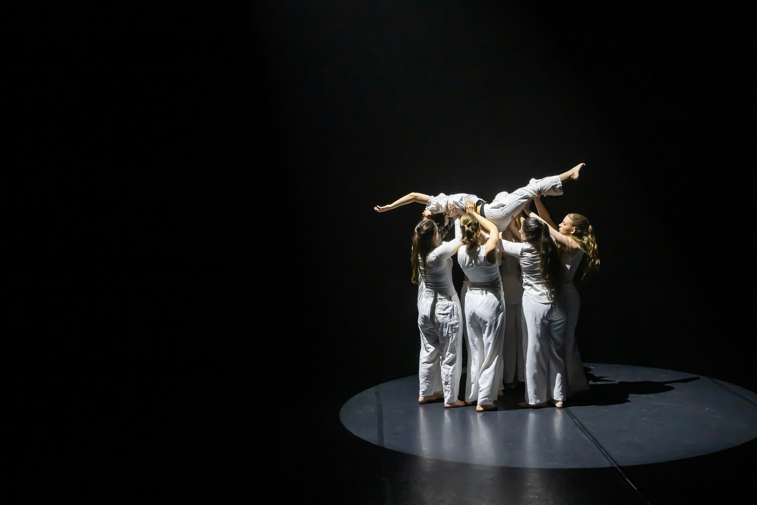 Dansuppvisning med Dansårets och dans-pedagogiska från Karlstads Universitet. Vårshow. Grupp lyfter en dansare. Koreograf Karin Lilja.