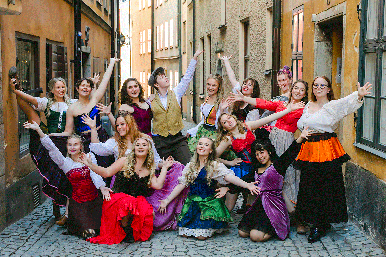Färgglad gruppbild med artister från Kulturamas Musikalartistutbildning i Stockholm. Gamla stan.