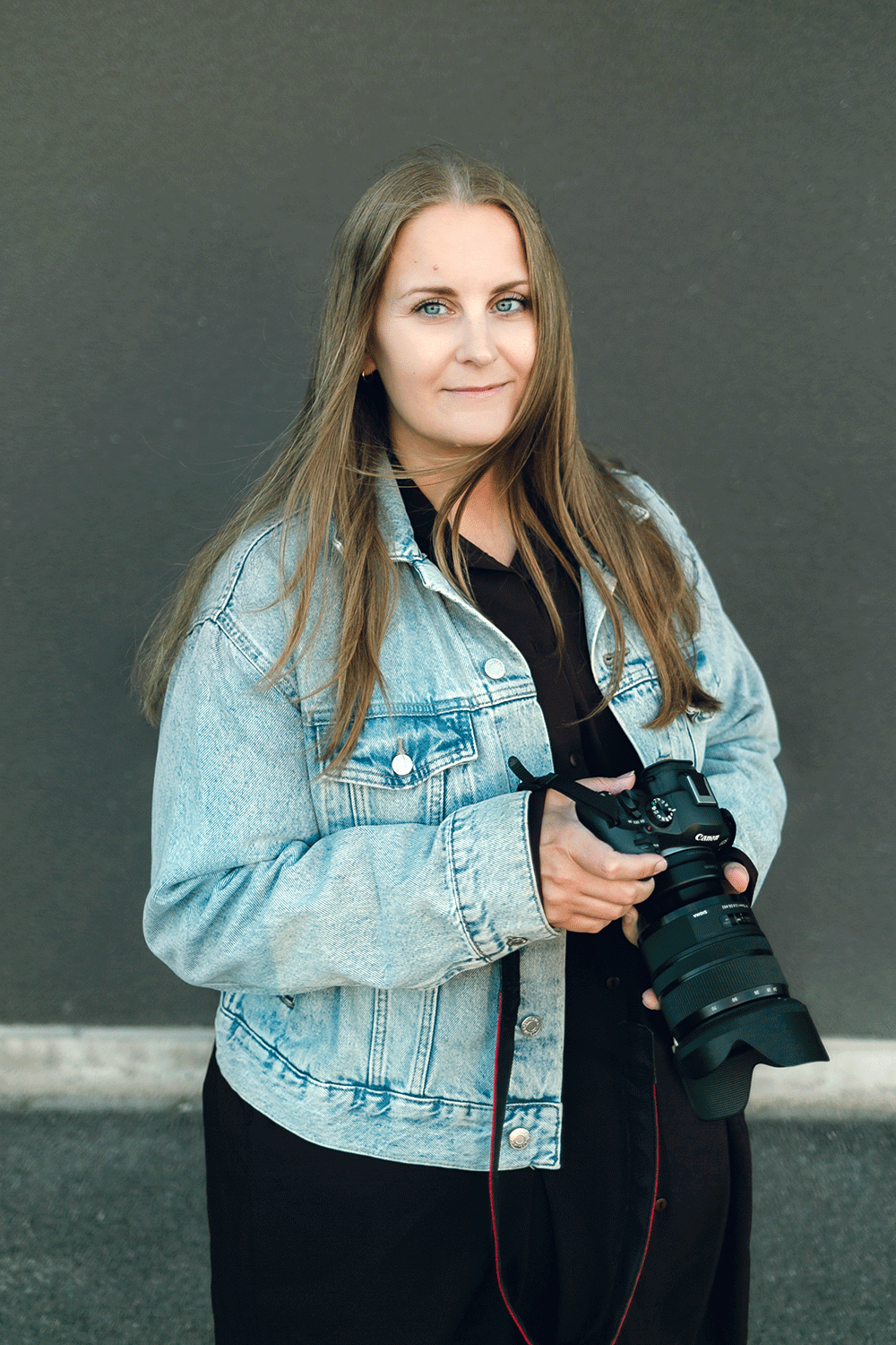 Porträtt på mig, fotograf Rebecca Nordin. Jeansjacka på mig och håller i kameran.