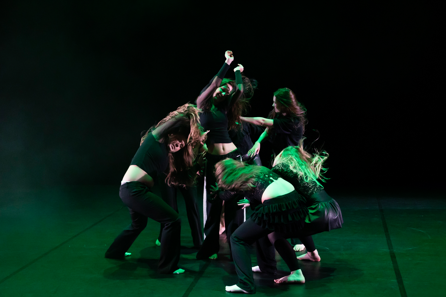 Dansföreställning med Dansstudion på Arenan i Karlstad. Koreografi av Evelina. Dansar i grupp i grönt ljus.