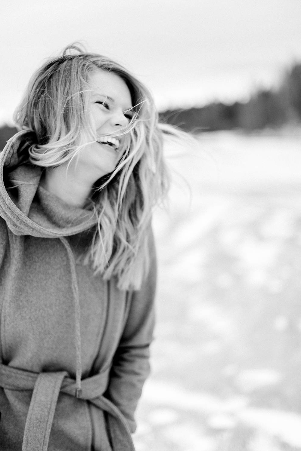 Fotograf Jeanette Dahlström skrattar och håret fladdrar. Svartvit.