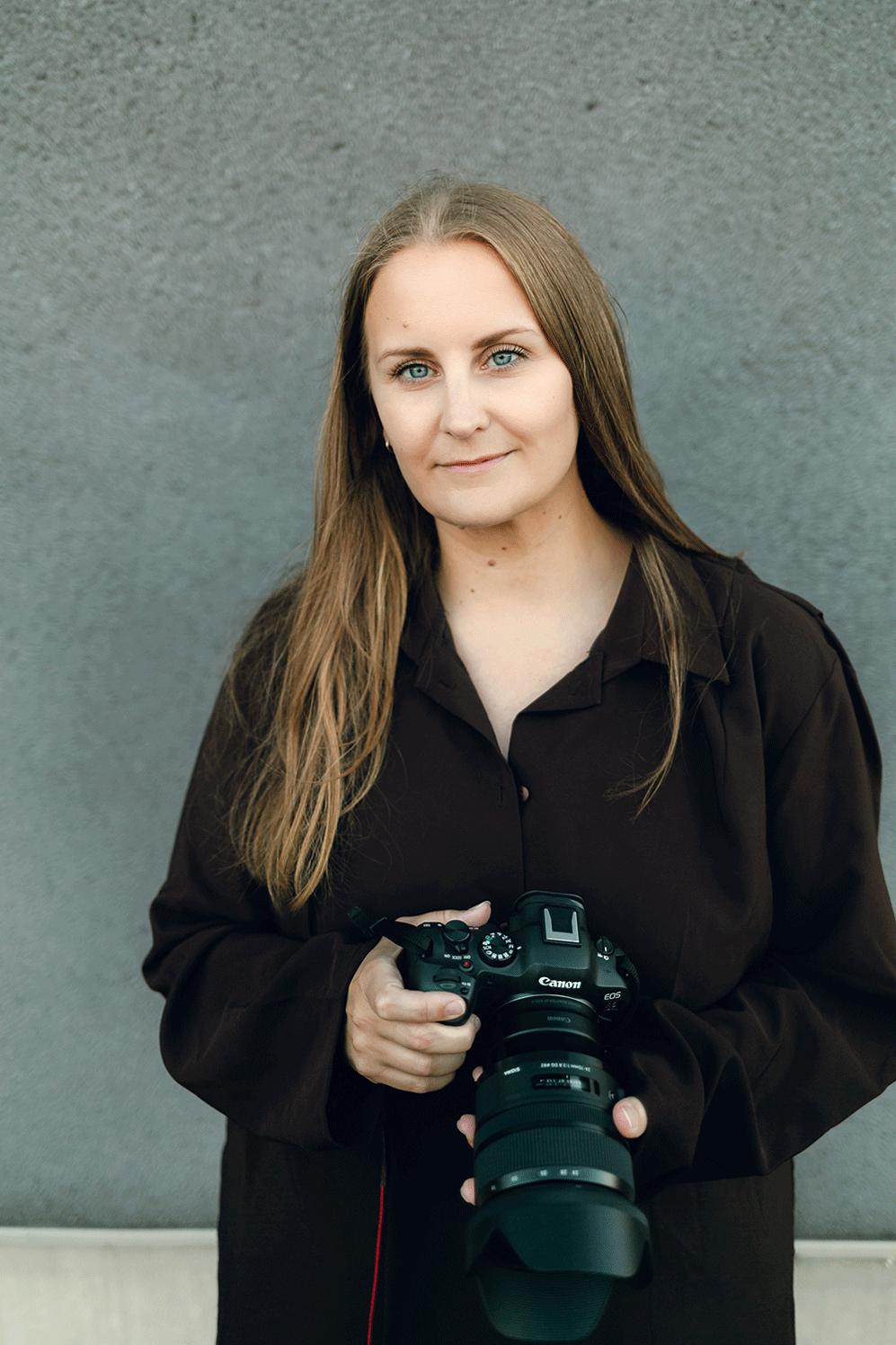 Porträtt på mig, fotograf Rebecca Nordin. Brun skjorta och håller kameran framför mig.